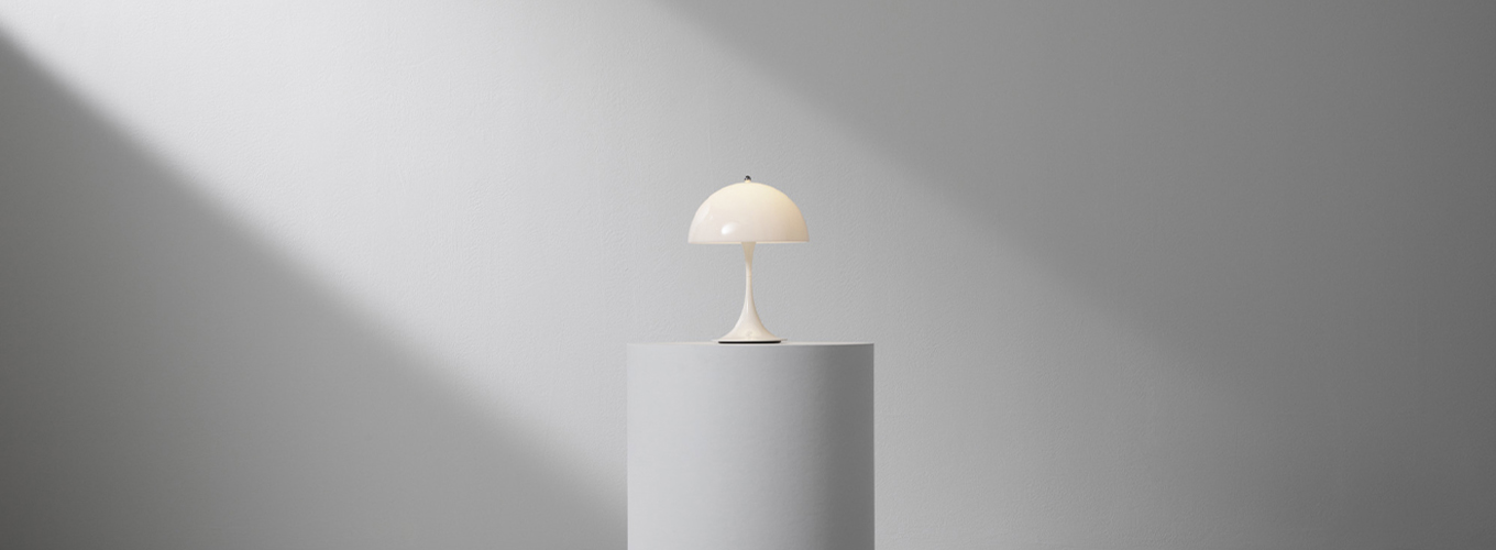 panthella 250 tragbare tischleuchte in opal weiß auf einem podest