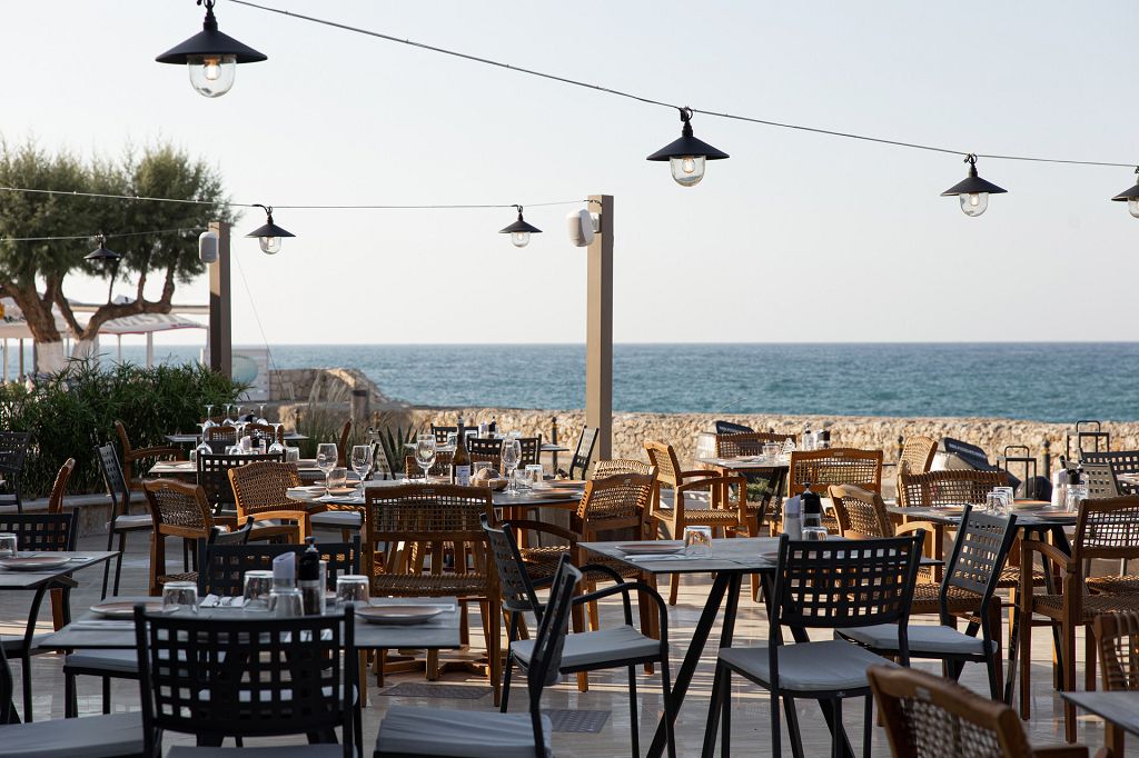 Große Außengastronomie mit vielen Terrassenstühlen und Tischen am Meer