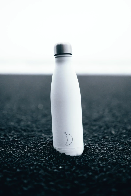 Trinkflasche der Marke Chilly`s in Weiß auf einem schwarzen Untergrund