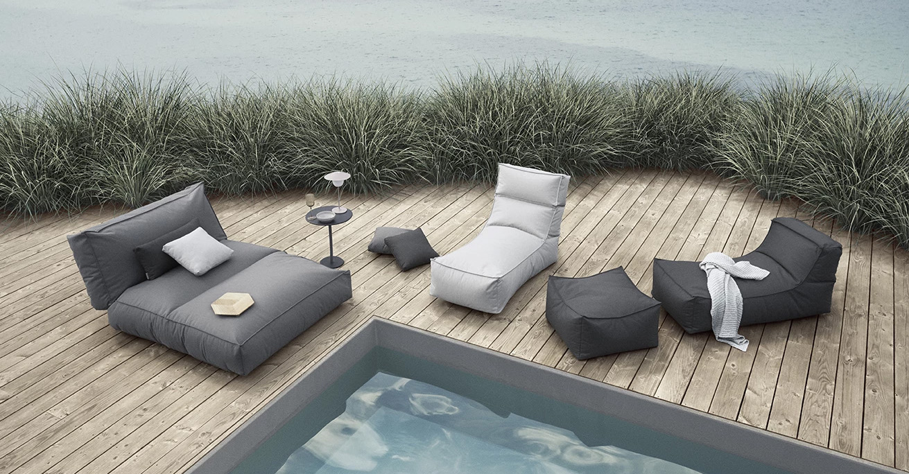 Blomus Stay Outdoor Bett Outdoor Lounge Produkte der Stay-Kollektion von Blomus auf einer Holzterrasse neben einem Pool
