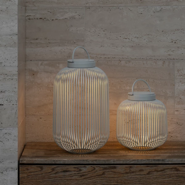 Zwei mobile LITO LED-Leuchten von Blomus , die eine Sitzbank beleuchten