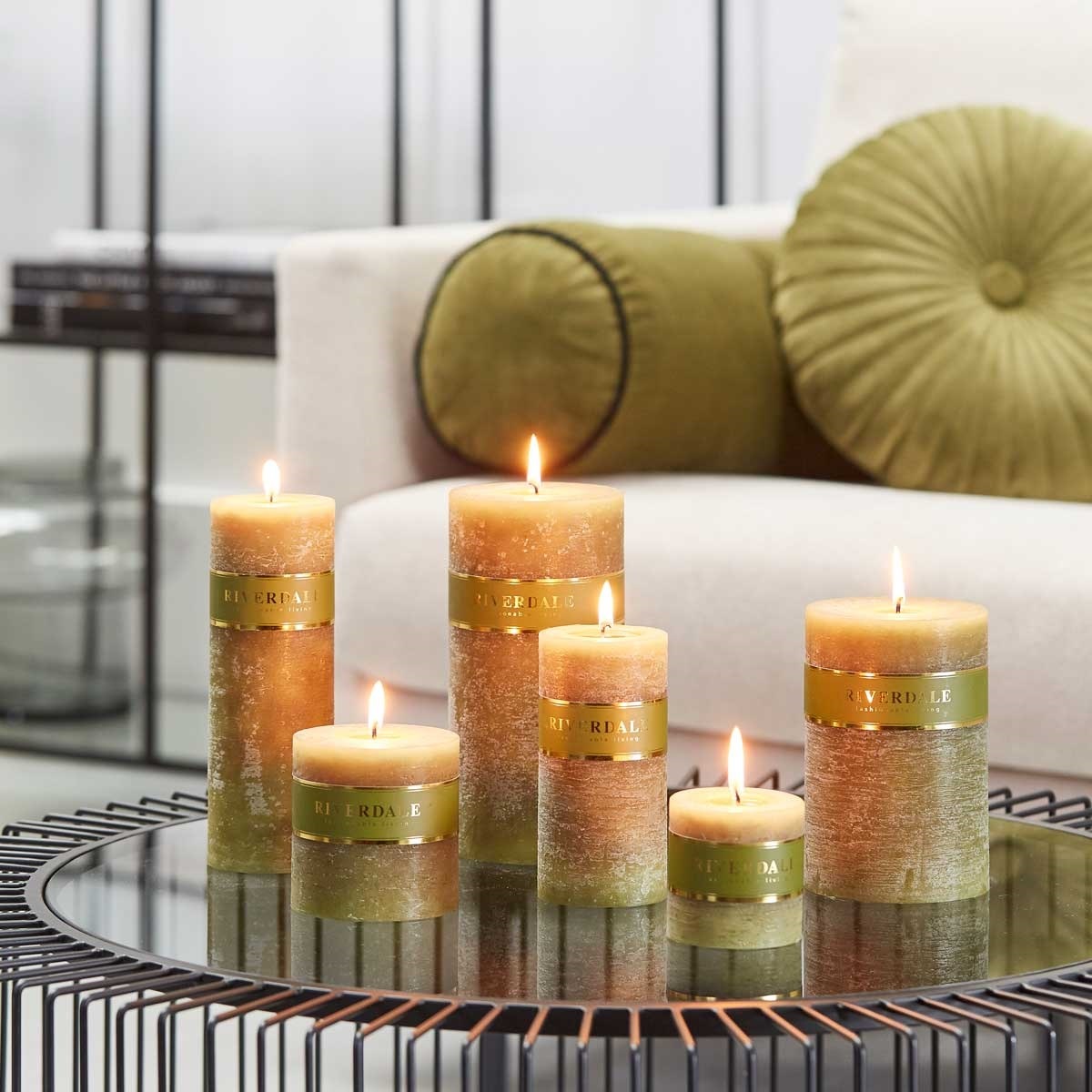 Riverdale Kerzen in verschiedenen Größen, auf einem Beistelltisch vor einer Couch