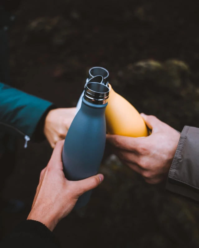 Chilly`s Bottle blau Drei Menschen stoßen mit drei Chilly`s Flaschen an