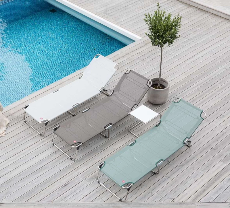 Drei Hotel Wellnessliegen auf einer Terrasse neben einem Pool