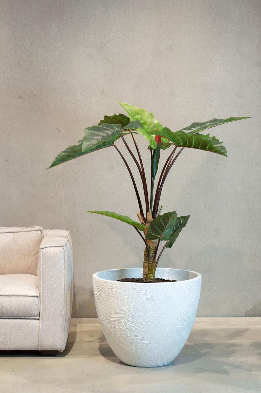 Große Alocasia Kunstpflanze von Fleur Ami neben einer Couch in einem weißen Übertopf