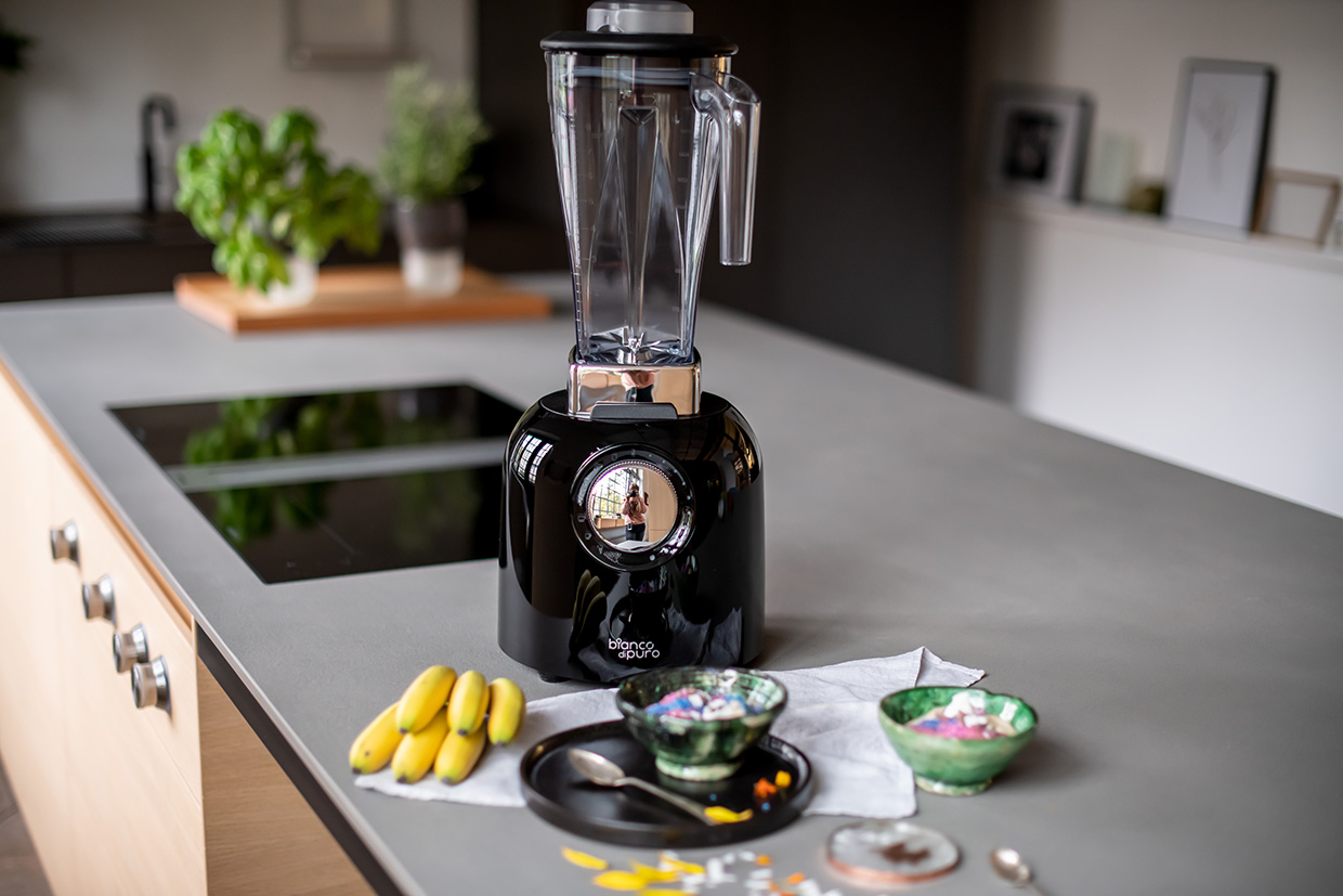 Bianco di Puro Hochleistungmixer Puro S auf einer Kücheninsel mit Zutaten