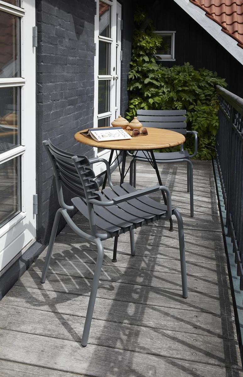 HOUE Outdoor Tisch Circum Teak Runder HOUE Outdoor Tisch Circum aus Holz mit zwei Stühlen auf einem Balkon